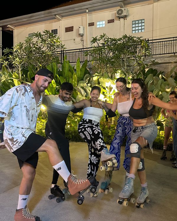 A group of friends on roller skates posing outdoors in the evening